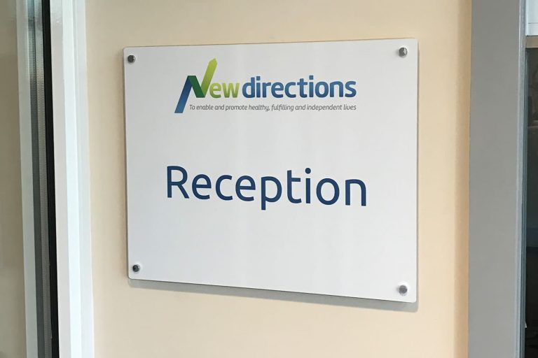 New Directions - internal white acrylic wayfinding plaque with silver stand off locators