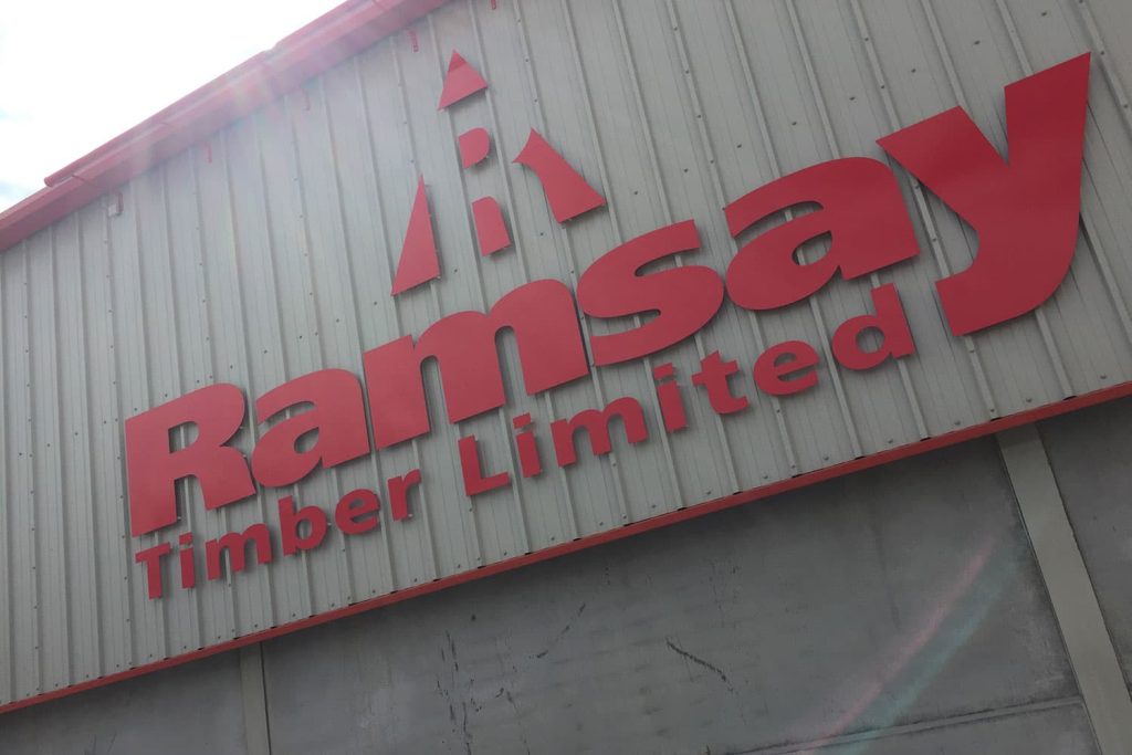 Ramsay Timber - red aluminium comp CNC cut letters mounted on stand-off locators with LED extra length trough light above