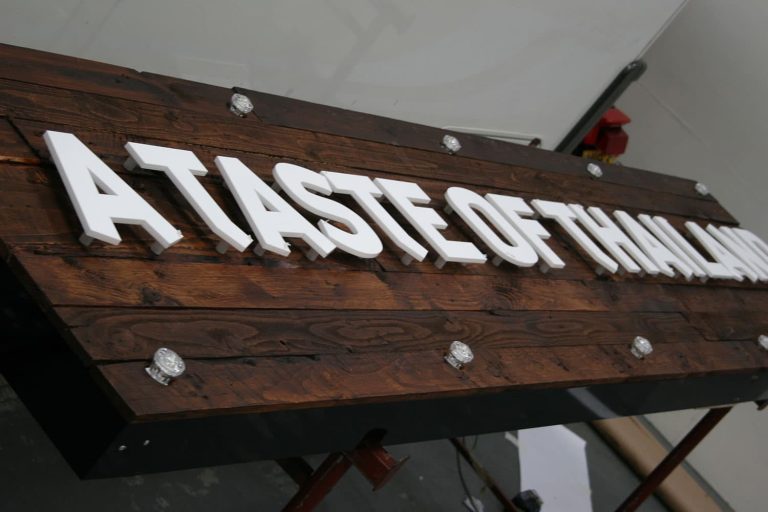A Taste of Thailand reclaimed wood faced sign tray with traditional cabochon lights and laser cut 10mm stand off acrylic letters